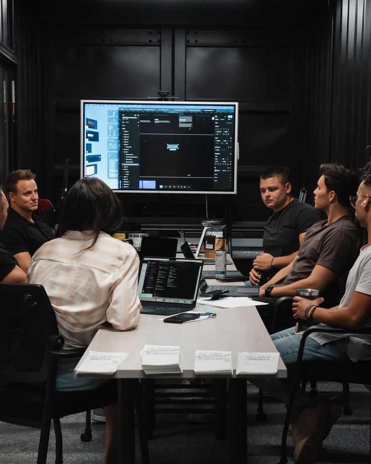 Engineers collaborating on software at a shared workstation
